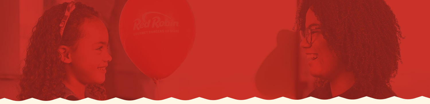 Team Member giving a balloon to young Guest